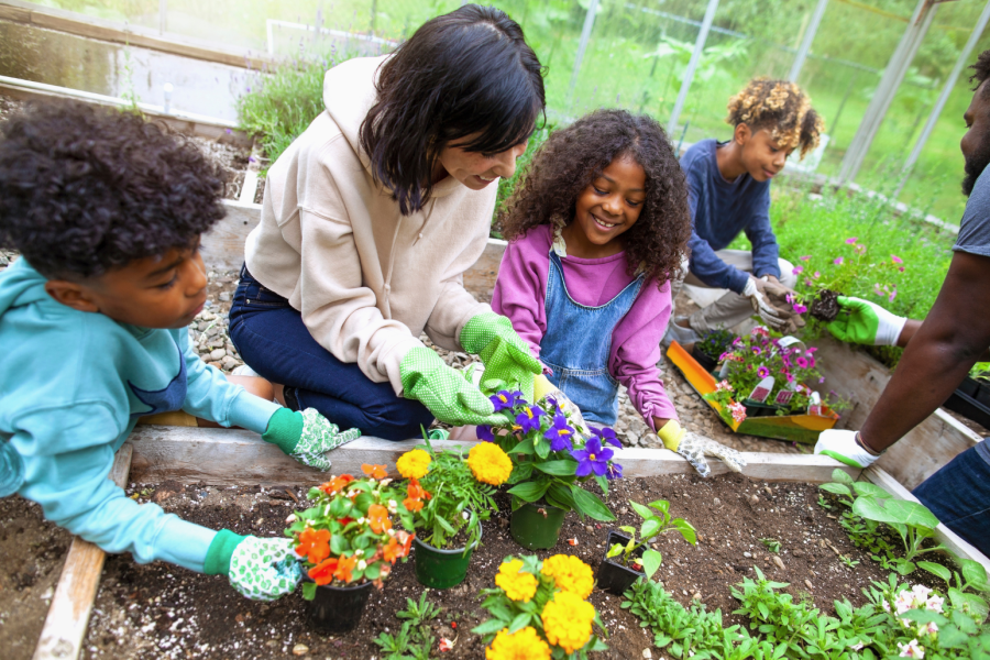 three children gardening with an adult